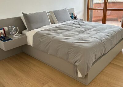 Camera da letto su misura con pannello boiserie e comodini sospesi