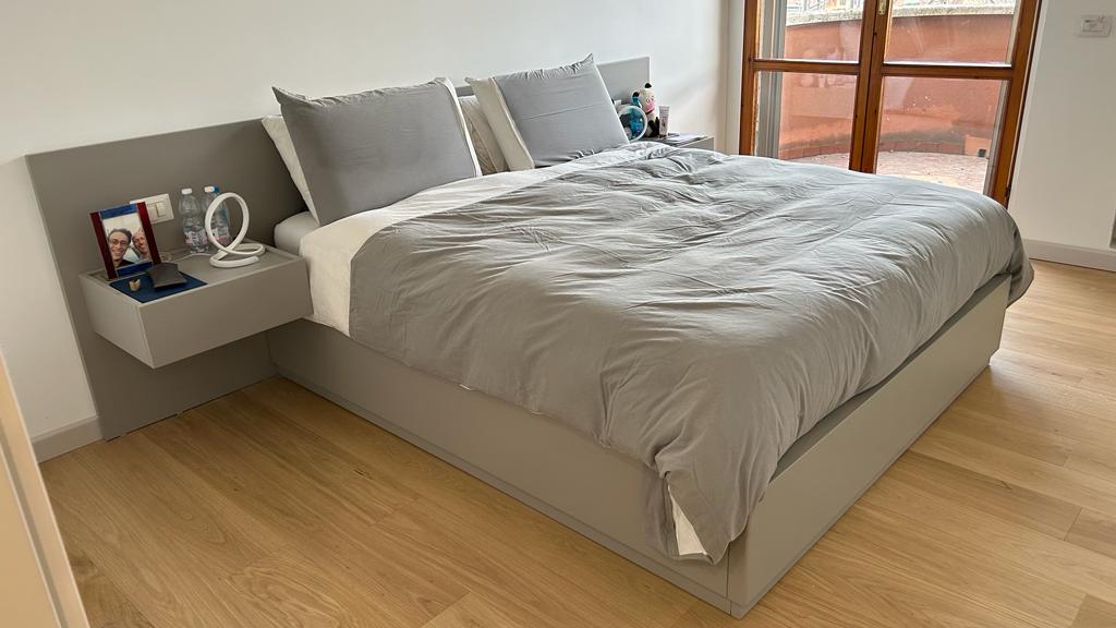 Camera da letto su misura con pannello boiserie e comodini sospesi